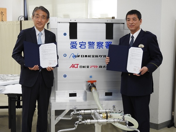 締結式:岡本社長(左)と江口博行 愛宕警察署長(右)